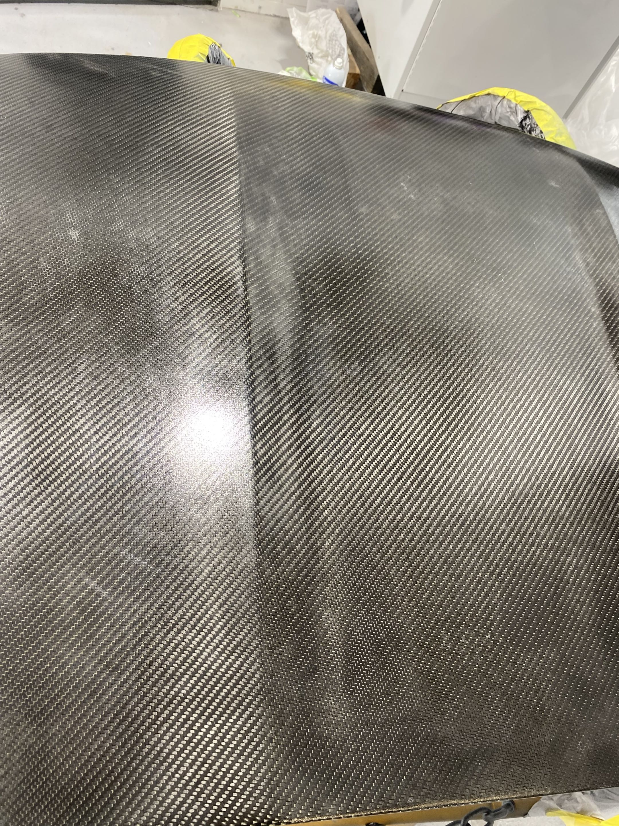 Before — hazy, swirled carbon fiber hood